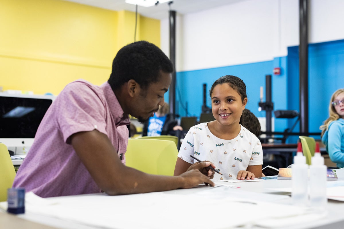 A man sits at a table with a young girl.