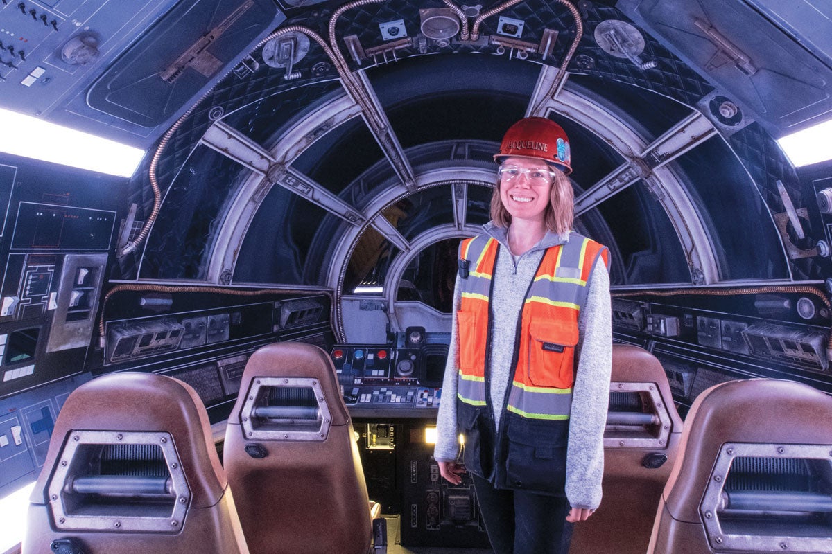 jacqueline king wearing hard hat and reflective vest standing inside millenial falcon