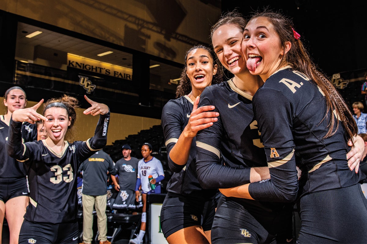 Three volleyball players pose for a photo after a game. UCF Fall 2019