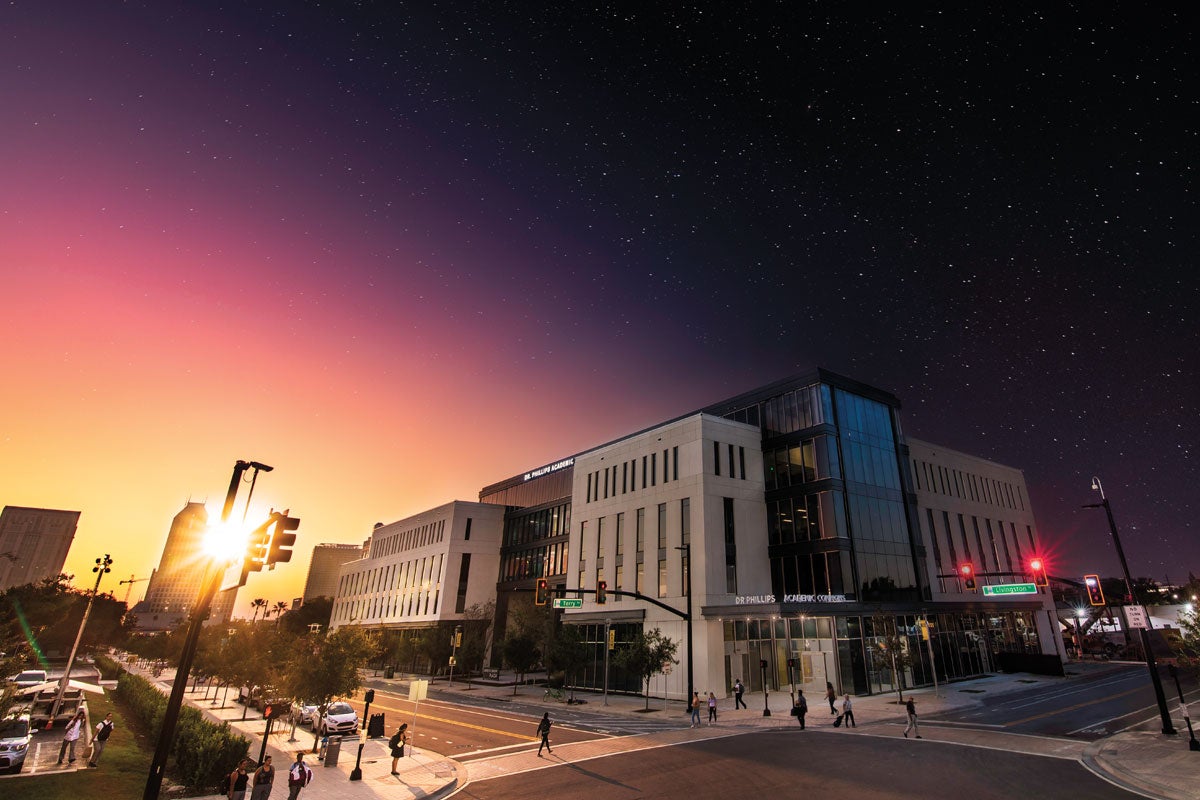 An image of the Dr. Phillips Academic Commons building with the sky behind it changing from day to night.