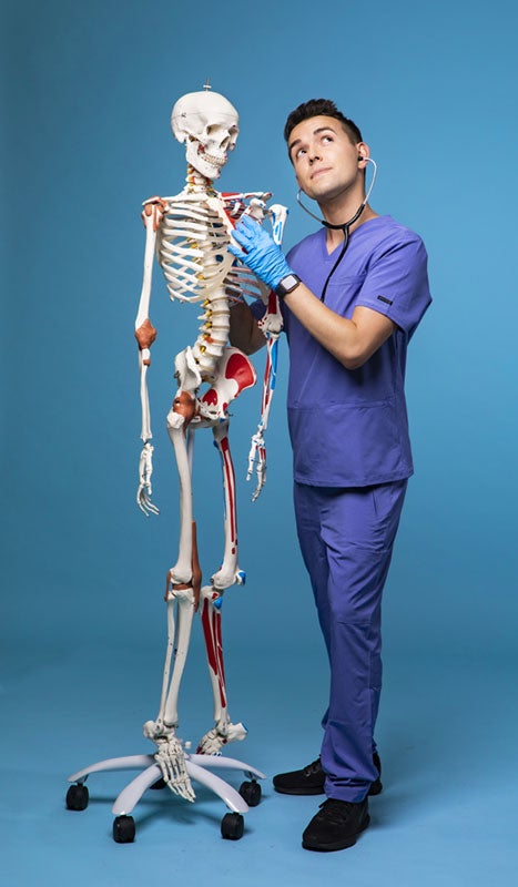 Nurse Blake uses a stethoscope to listen to a skeleton.