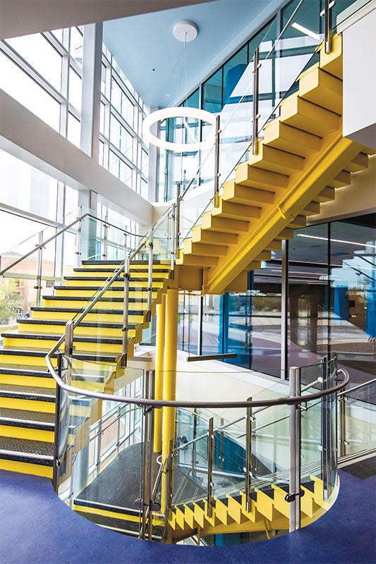 Yellow staircases near large windows.