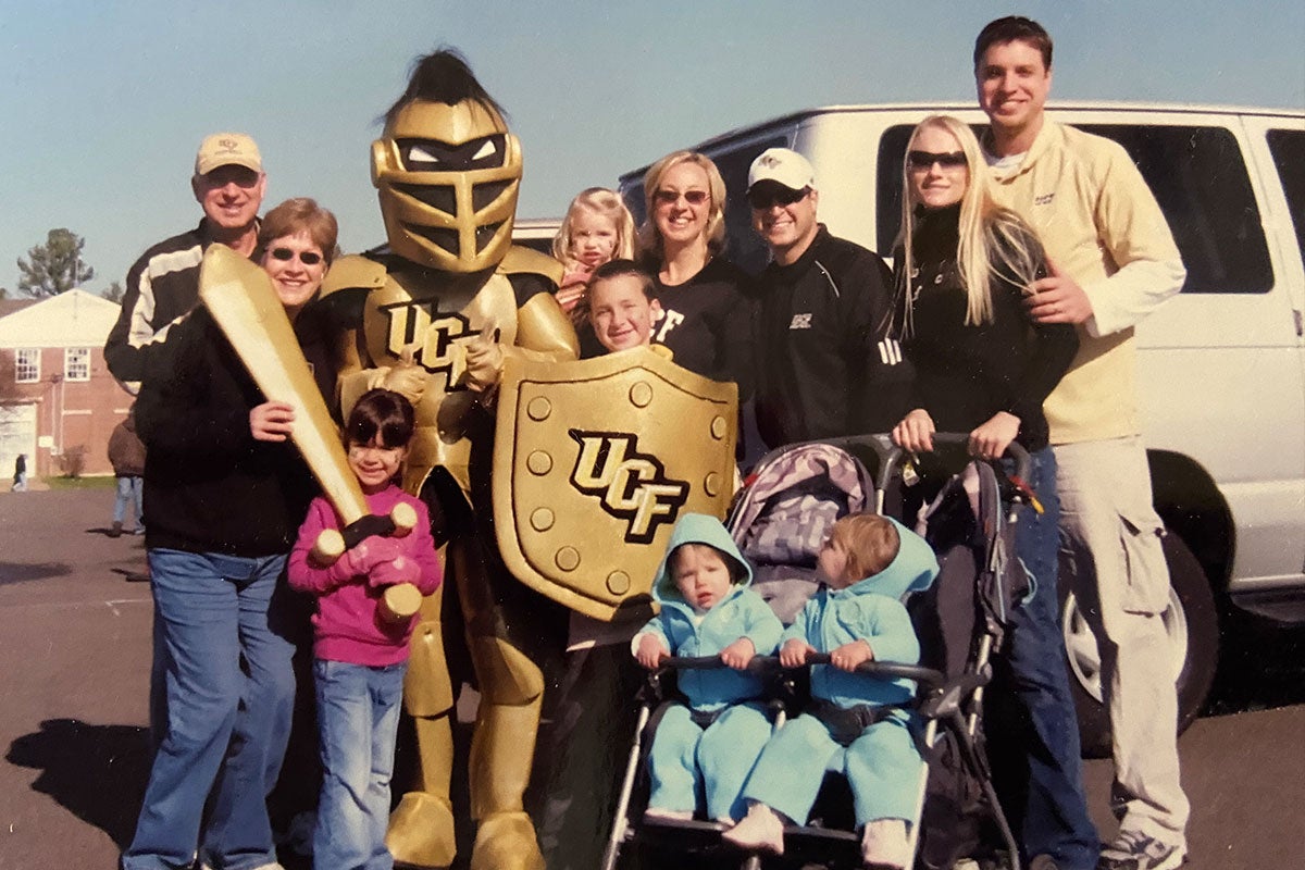 The Aliberti and Wright family pose for a photo with Knightro in a parking lot.
