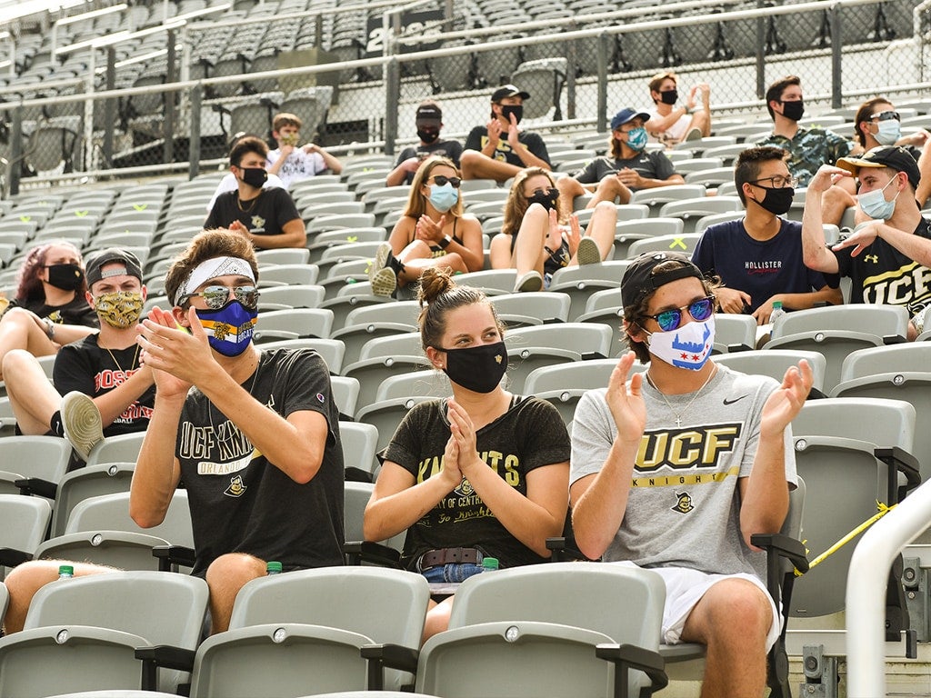 students sitting in physically distanced groups in stadium stands