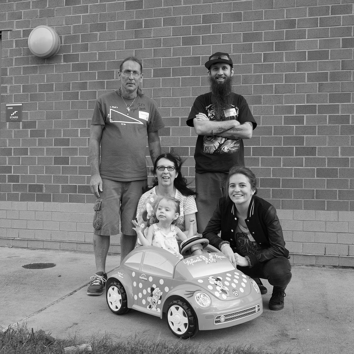 Ava Brown in a Go Baby Go! card with her family posed around her