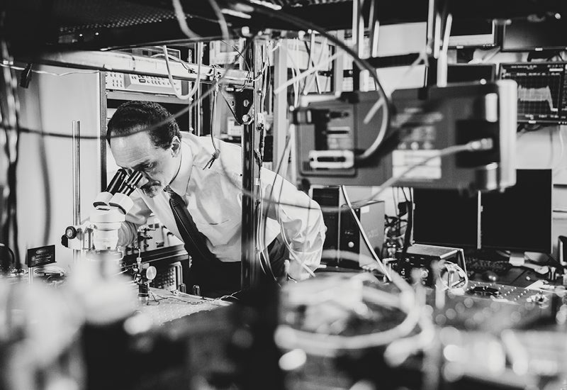 Peter Delfyett looking into a microscope