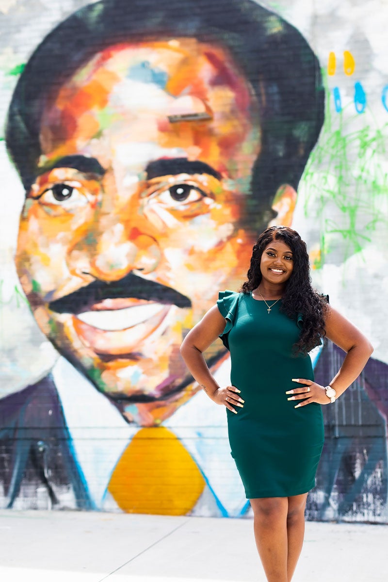 Derreasha Jones in front of the John T. Washington plaque