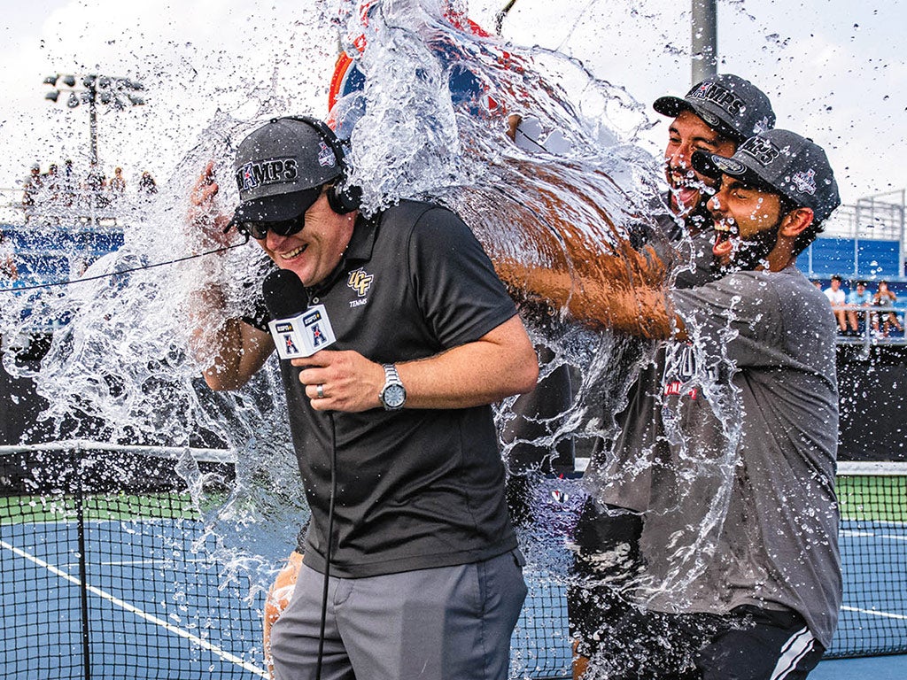 UCF men's tennis head coach John Roddick gets water dumped on him by three athletes in celebration of a championship