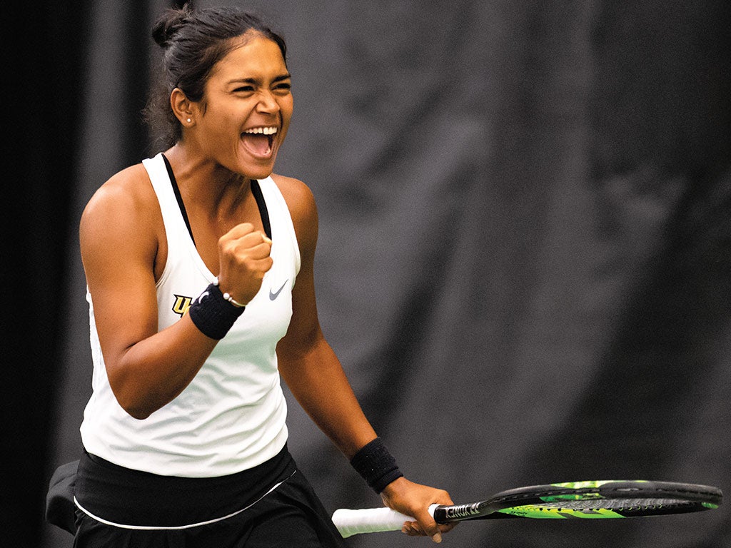 Women's tennis player clinches fist in celebration on the court