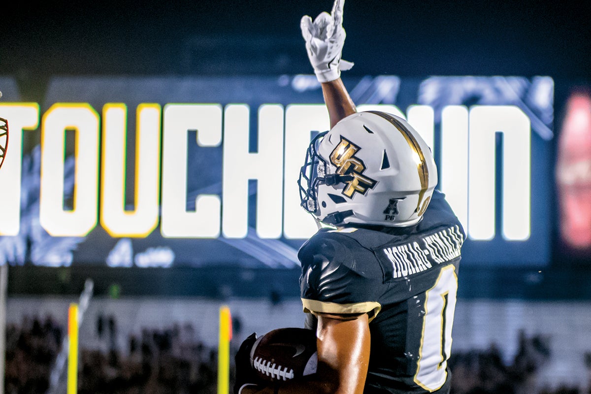 A football player holds up one finger after scoring a touchdown