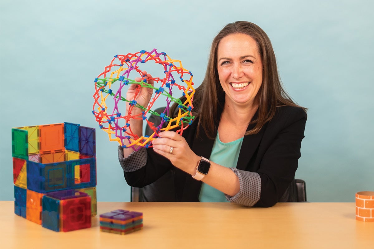 Dalena Dillman Taylor smiles while holding a Hoberman sphere.