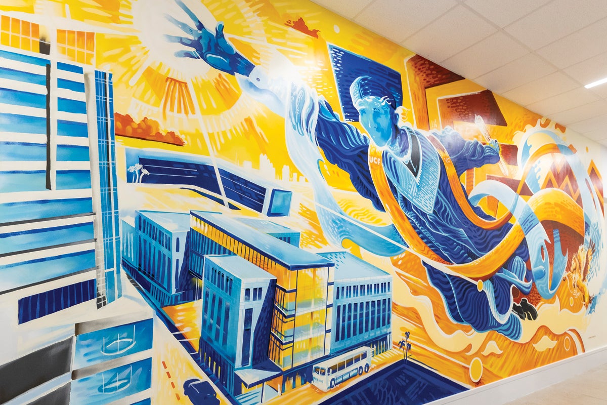 A mural of a graduate in a cap and gown reaching toward the sun while floating over a city.
