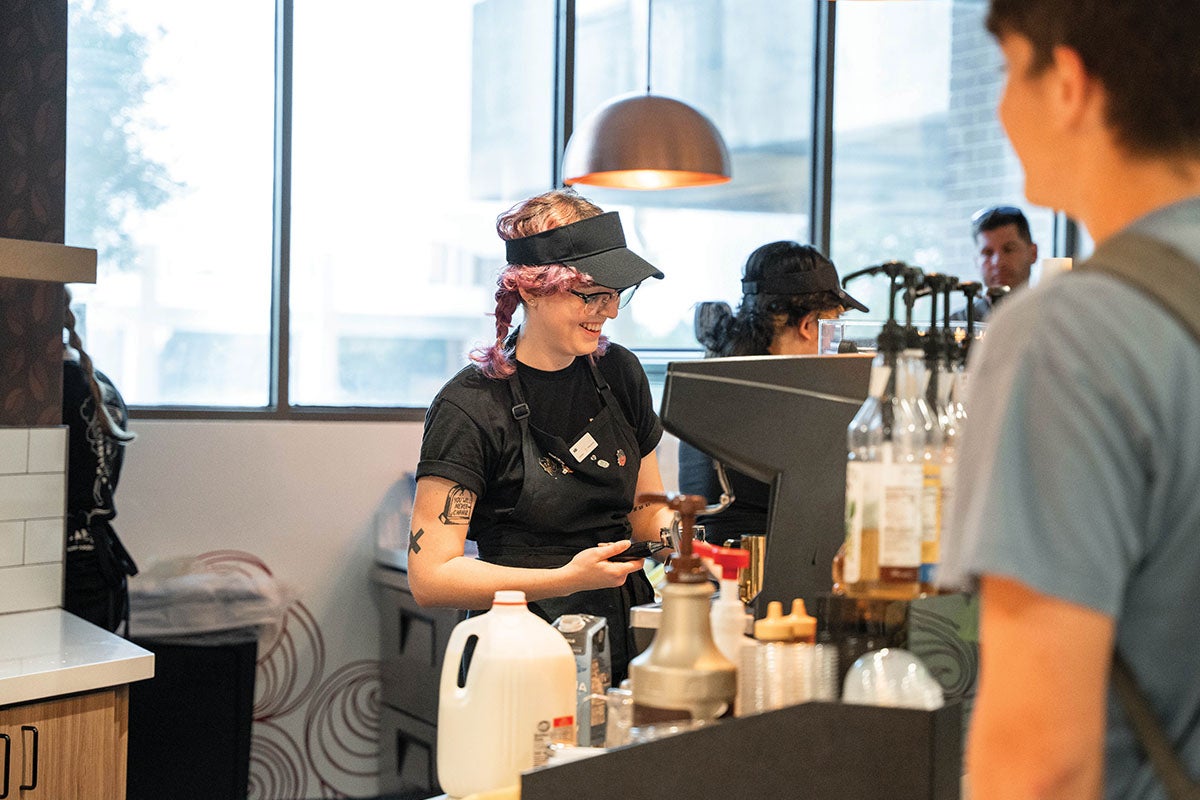 A barista makes a customer's coffee order.