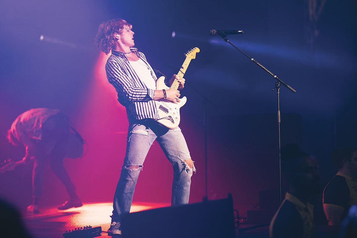 A man playing a guitar on stage 