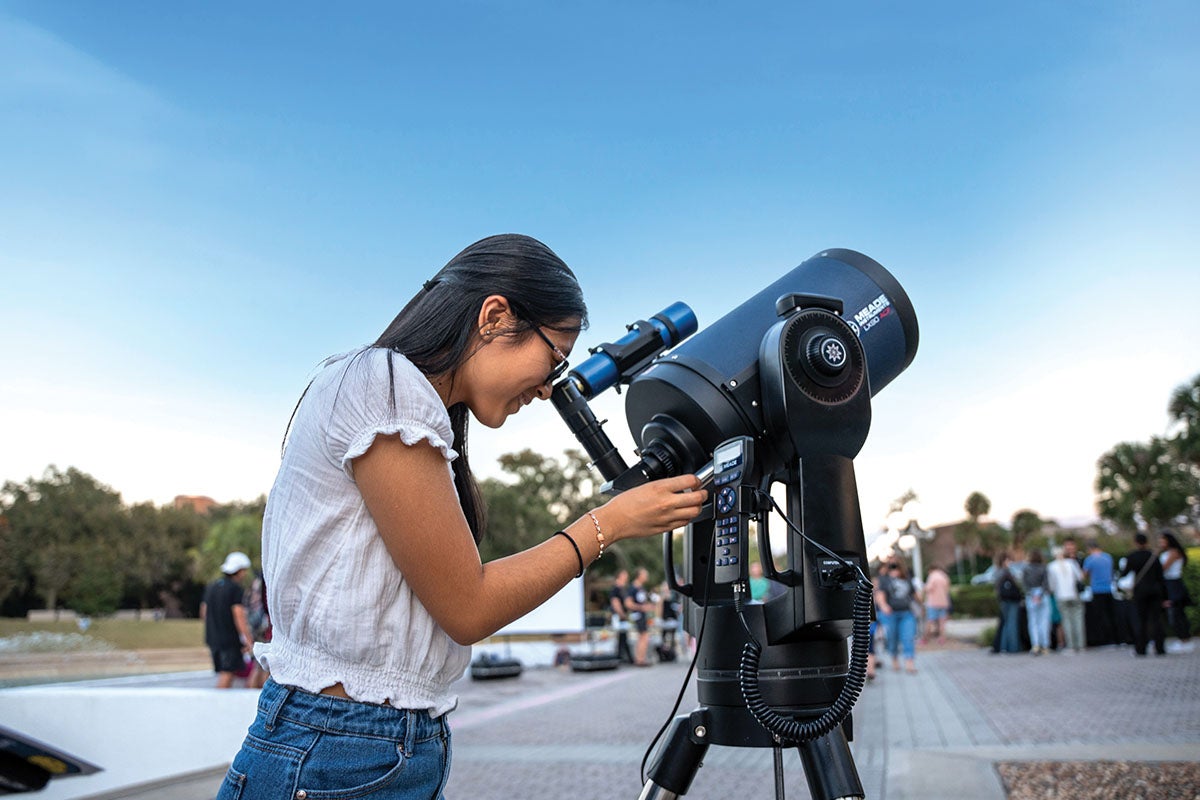 Photo of a student looking through a powerful telescope