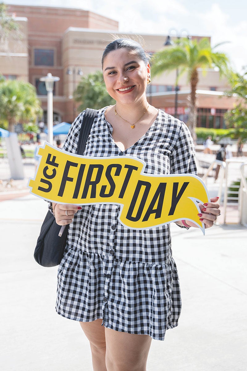 Photo of a student holding a sign with the words UCF First Day printed on it