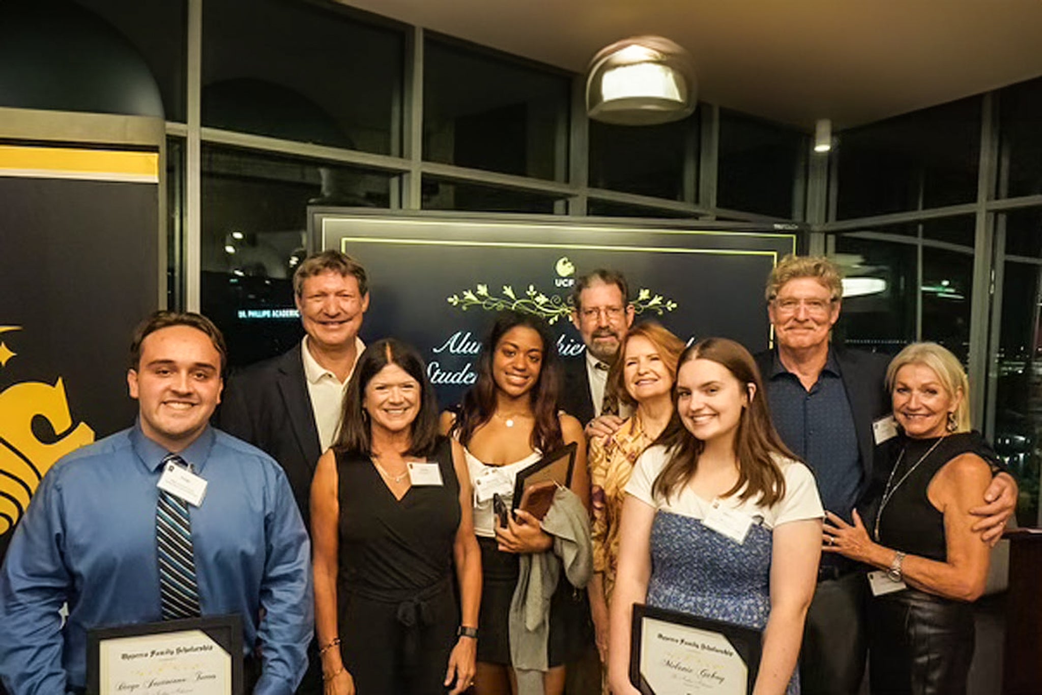 A group of donors posing for a photo with students