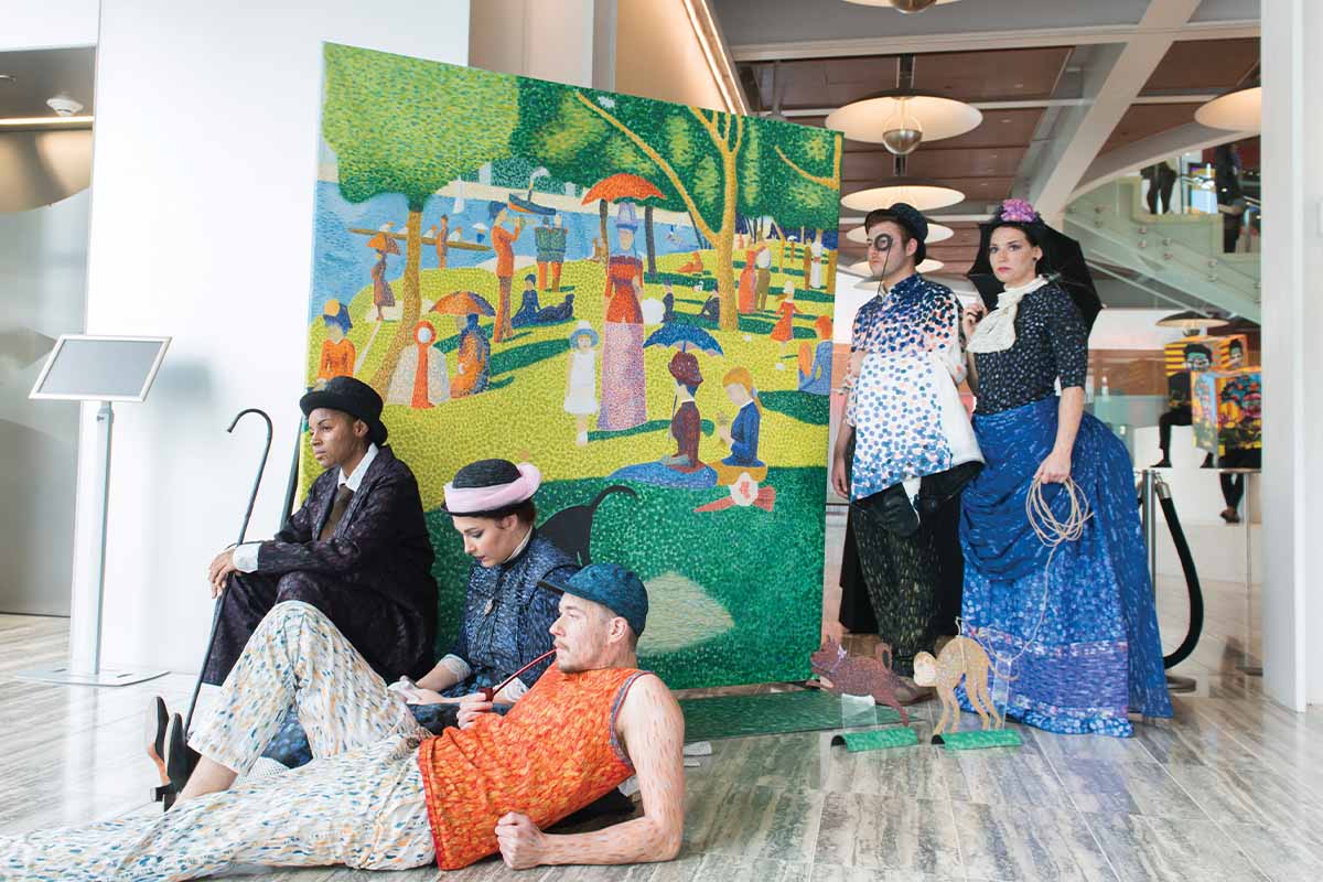 Group of UCF students model in a life-size painting of Georges Seurat’s A Sunday Afternoon on the Island of La Grande Jatte