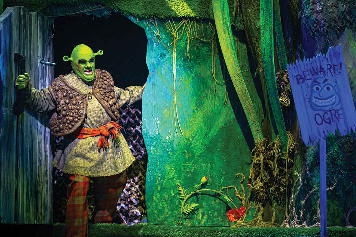 Shrek emerges from behind a tree in UCF's Shrek: The Musical performance during UCF Celebrates the Arts