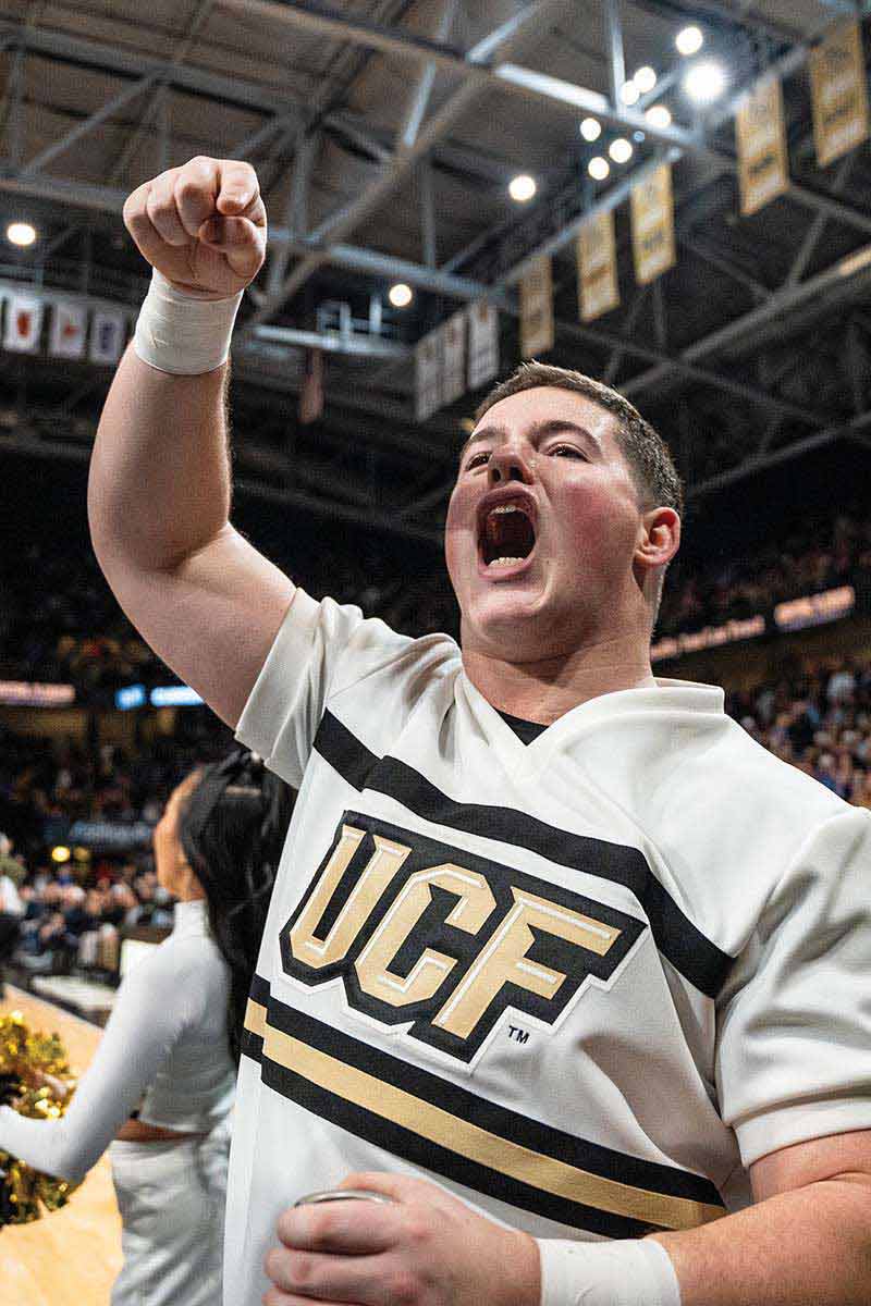 During The UCF vs. Kansas men's basketball game at Addition Financial Arena, a member of UCF's cheer team amps up the crowd.
