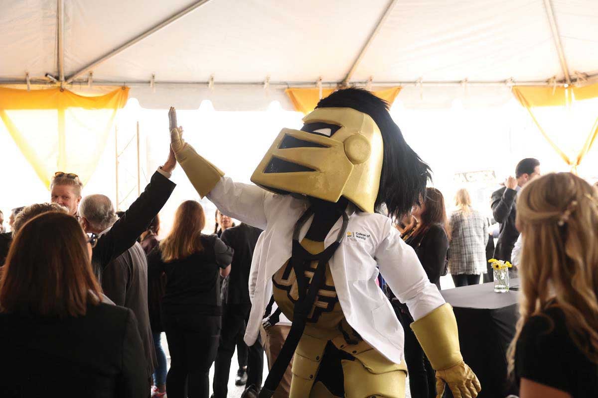 UCF mascot Knightro gives a person a high five during the Dr. Phillips Nursing Pavilion groundbreaking ceremony at Lake Nona.