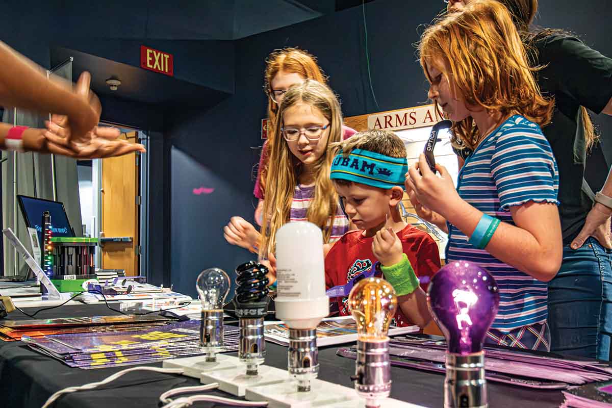 Kids looking at an exhibit with light bulbs