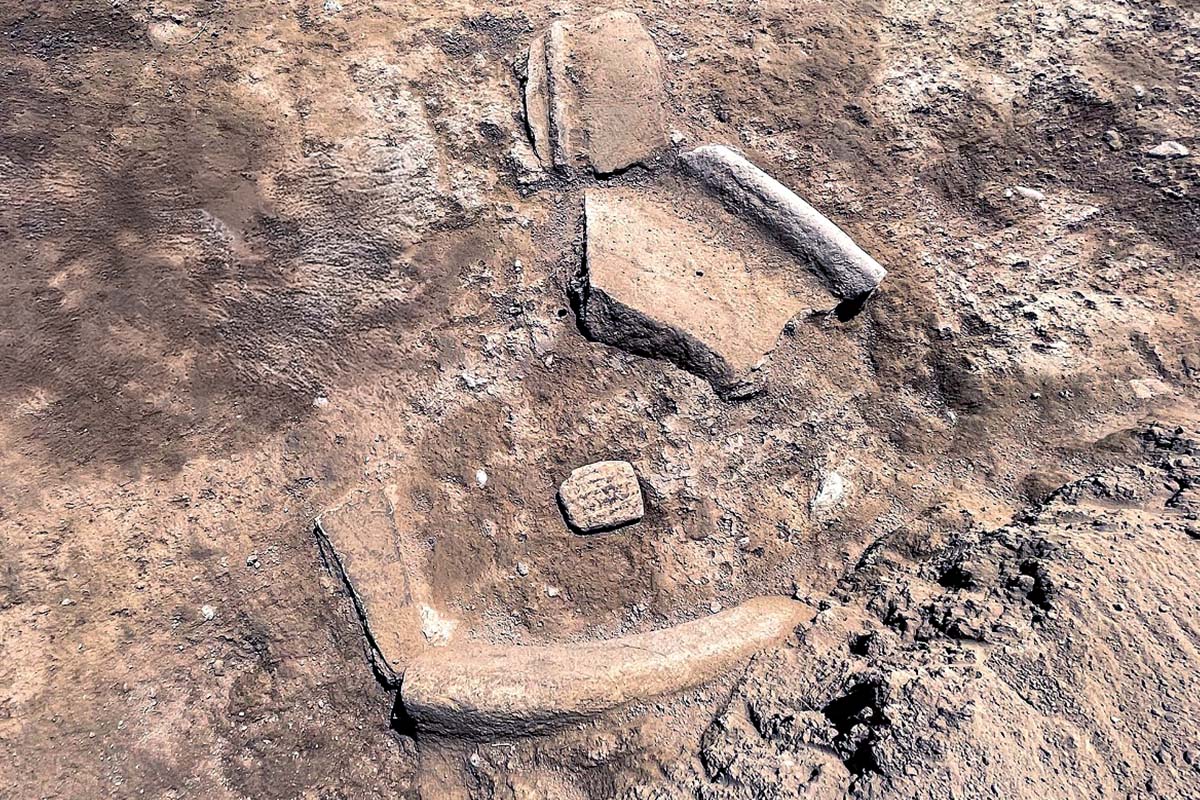An overhead shot of a tablet on the ground at an excavation site